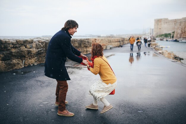 Guy and woman have fun on the street in the rain