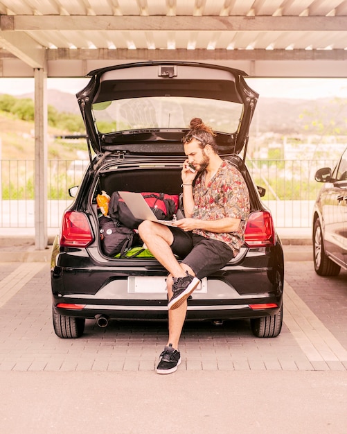 Free photo guy working on laptop in trunk