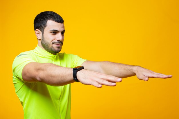 Guy in yellow t shirt stretching arms forward