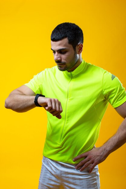 A guy in yellow t shirt watches a time