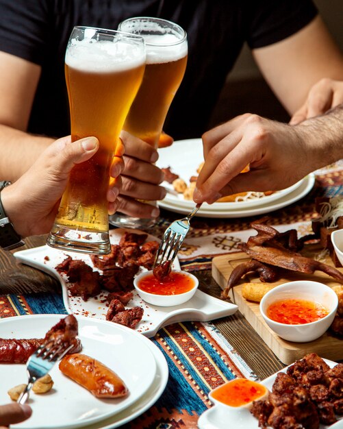 Guys drinks beer with various snacks