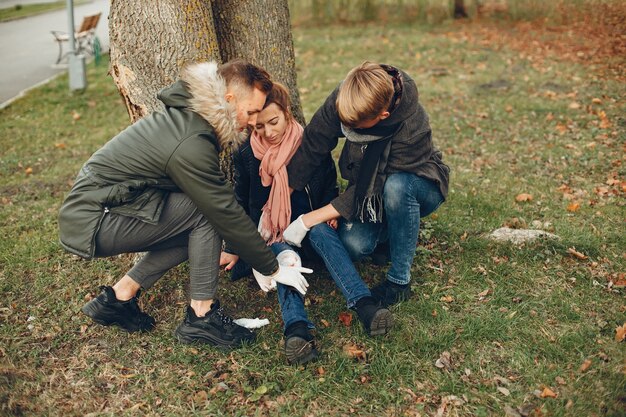 Guys help a woman. Girl with a broken leg. Providing first aid in the park.