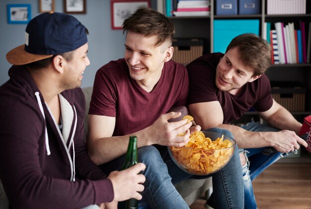 Guys relaxing with snacks and beers