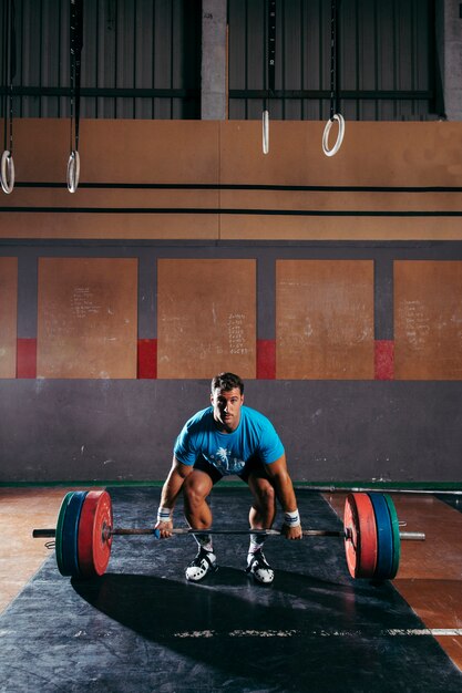 Gym concept with man about to lift barbells