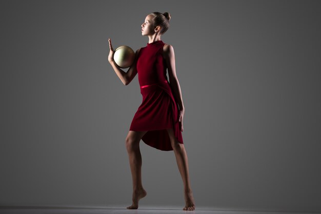 Девушка-гимнастка, танцующая с мячом