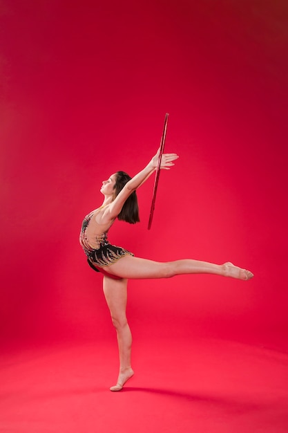 Free photo gymnast making positions with the hoop