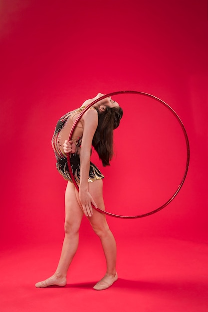 Free photo gymnast making positions with the hoop