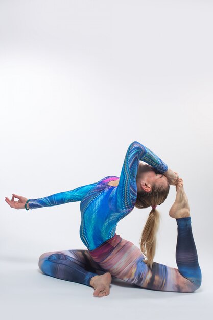 Gymnast in a multi-colored tights during streching