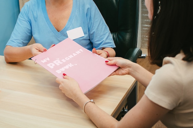 The gynecologist gives the girl a pregnancy diary. my pregnant book.