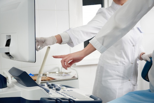 Gynecologist ready to do transvaginal ultrasound with wand and exam a woman