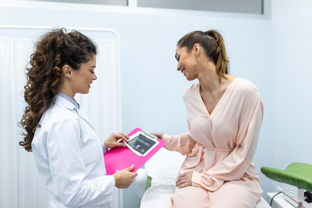 Gynecologist talking with young female patient during medical consultation in modern clinic Patient with a gynecologist during the consultation in the gynecological office