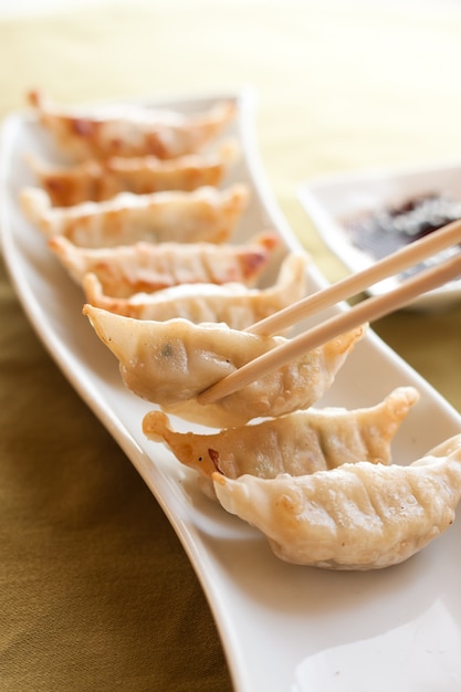 Gyoza and chopsticks on white plate