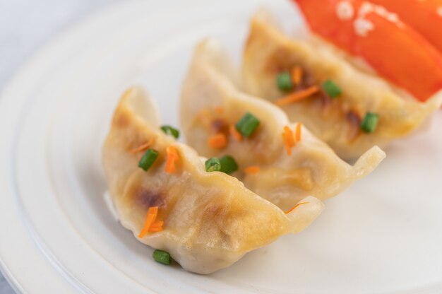 Gyoza in a white dish.