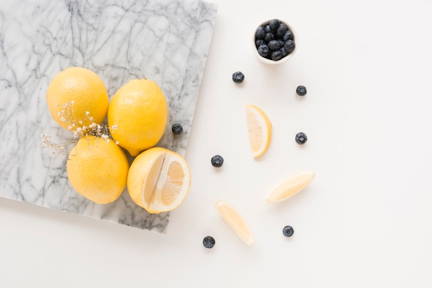 Gypsophila flower with lemons and blueberries on white background