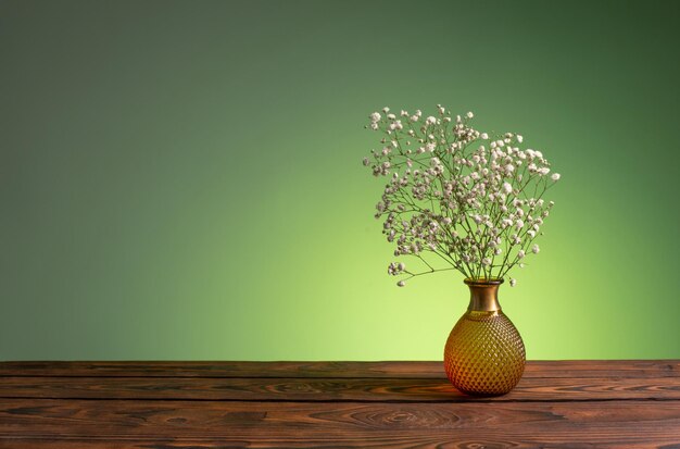 녹색 배경에 꽃병에 석고 꽃 프리미엄 사진