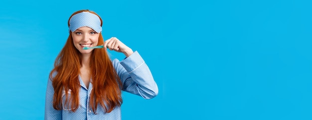 Foto gratuita abitudini igiene e concetto di stile di vita carino donna rossa femminile europea in indumenti da notte maschera da sonno sm