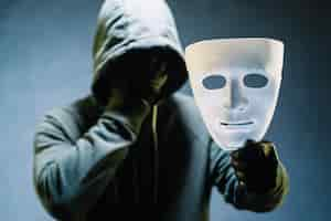 Free photo hacker holding mask