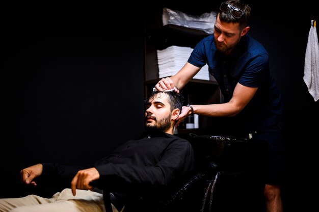 Hair stylist washing his client's hair