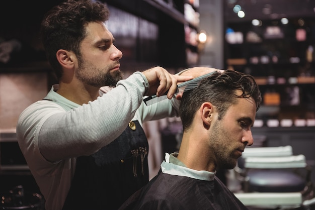 Hairdresser combing clients hair