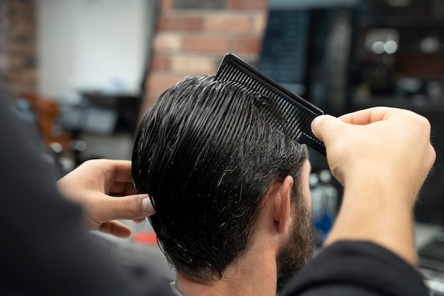 Hairdresser combing hair close up