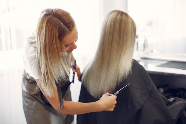 Hairdresser cut hair her client in a hair salon