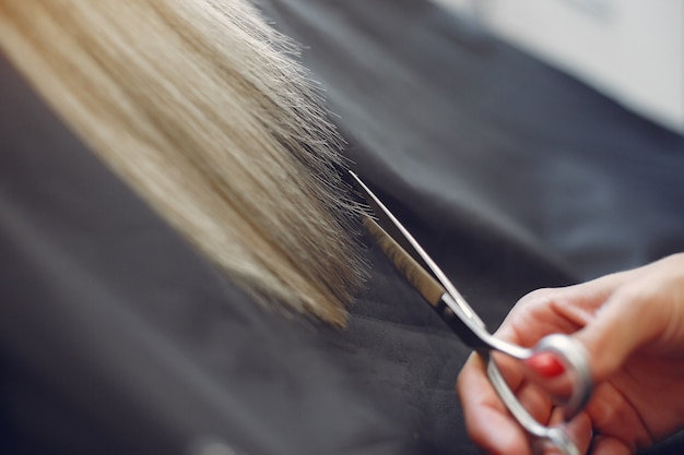 Hairdresser cut hair her client in a hair salon