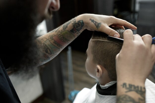 美容師が小さな男の子の髪をカット