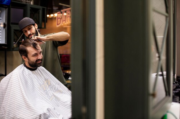 理髪店で男の髪を切る美容師
