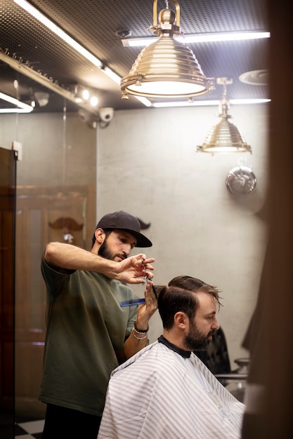 Hairdresser cutting a man's hair at the barber shop