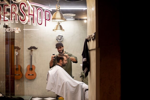 Hairdresser cutting a man's hair at the barber shop