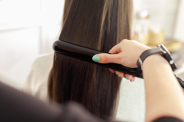 Hairdresser does hair style of woman