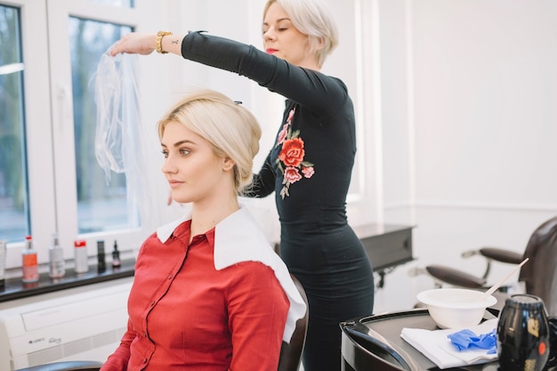 Hairdresser preparing client for procedure