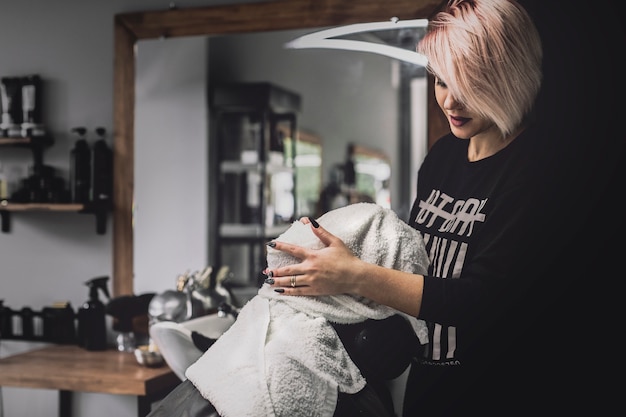 Free photo hairdresser putting face of man in towel