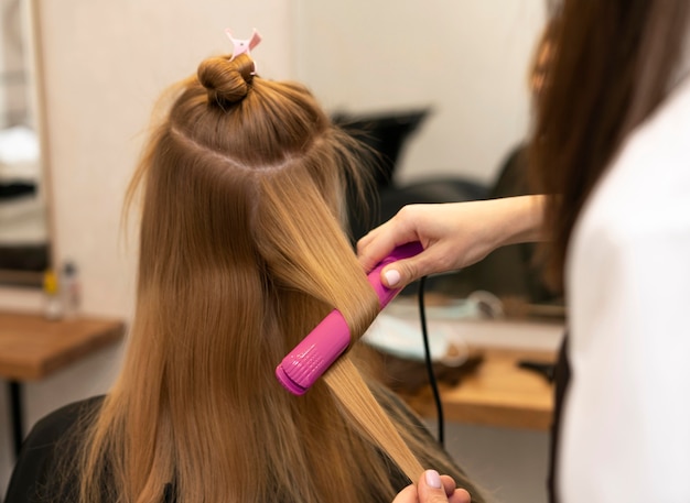 Foto gratuita parrucchiere che disegna i capelli di un cliente al salone