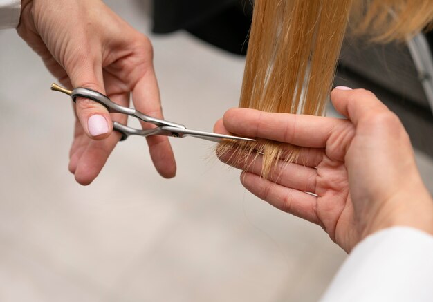 Парикмахер укладывает волосы клиента