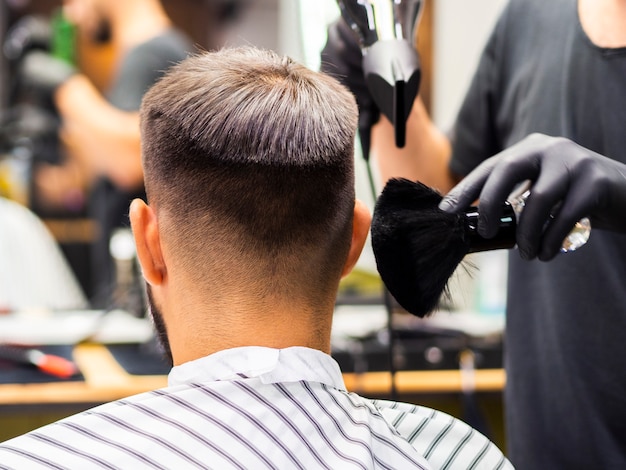 Hairdresser using a shaving brush and a dryer