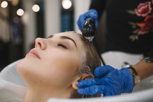 Hairdresser washing head of client after dyeing