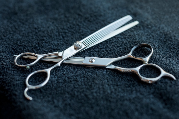 Hairdressers scissors lying on dark cloth