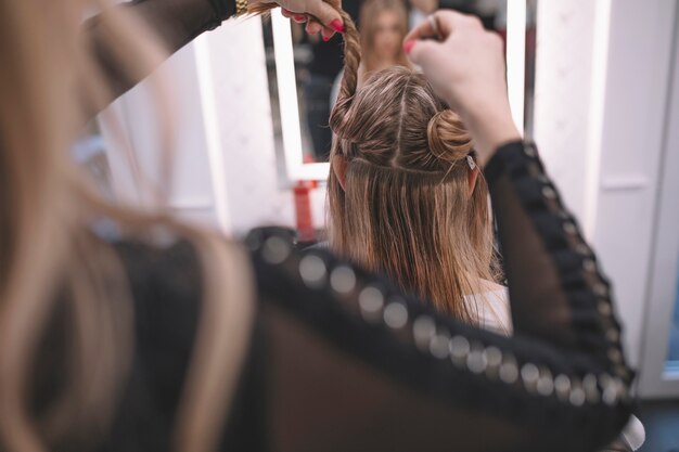 Hairstylist preparing client for hairstyle