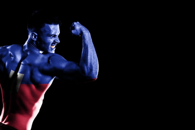 Haiti flag on handsome young muscular man black background