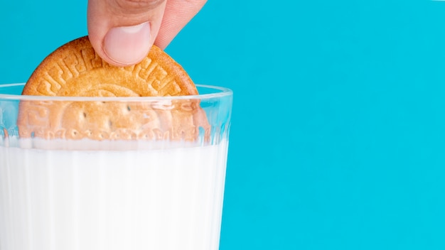 Free photo half of biscuit dipped in a glass of milk