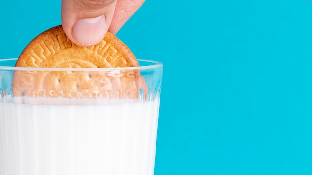 Половина печенья опускается в стакан молока
