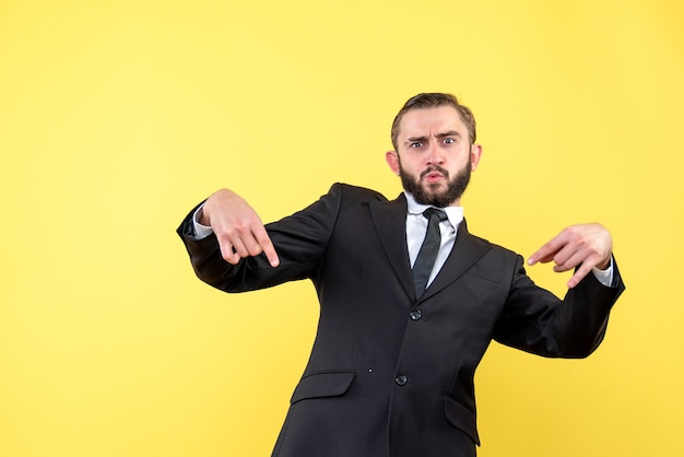 Half body portrait of proud bearded man while standing over yellow