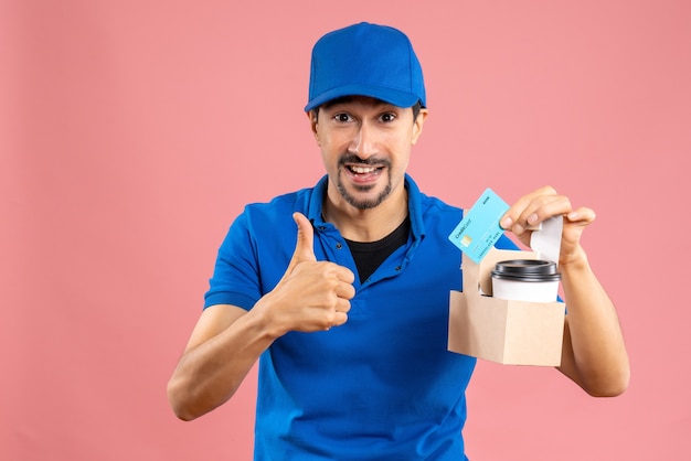 Half body shot of confident male delivery guy wearing hat holding orders and bank card making ok gesture