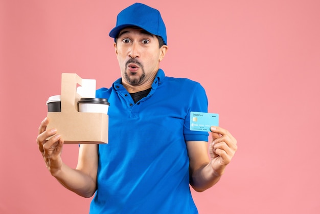 Half body shot of surprised male delivery guy wearing hat holding orders and bank card