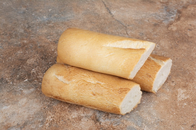 Half cut baguette bread on marble surface