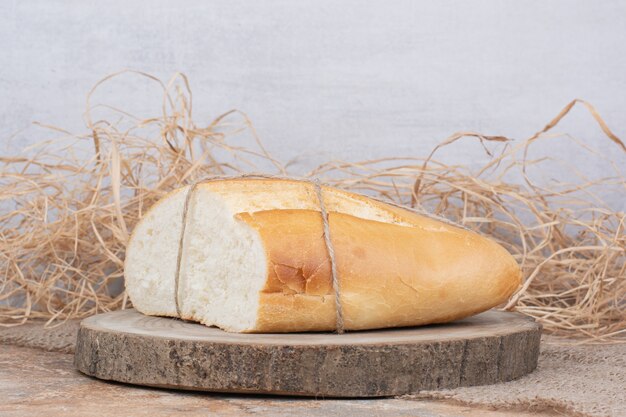 Half cut bread tied with rope on wooden piece