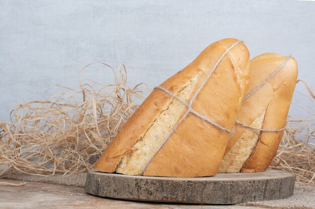 Half cut bread tied with rope on wooden piece