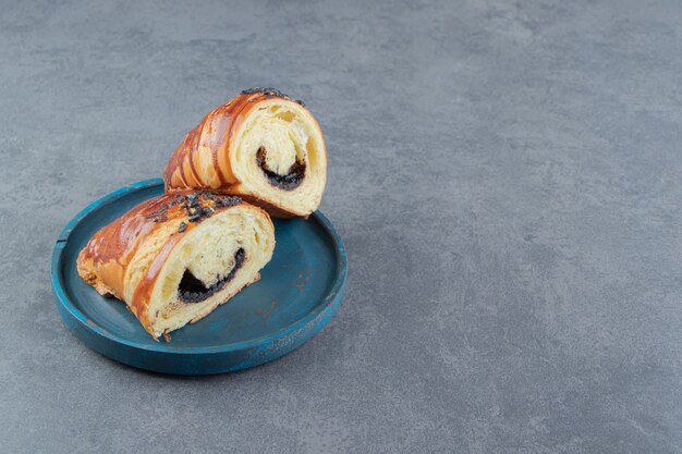 Half-cut croissants with chocolate on blue plate.