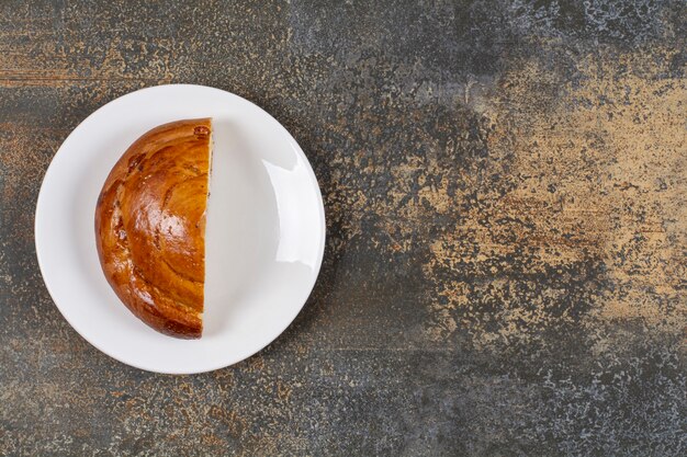 Half cut fresh pastry on white plate. 